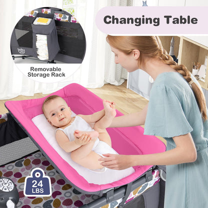 BABY JOY 5 in 1 Pink Pack and Play, Portable Baby Playard with Bassinet & Changing Table, Infant Pink Girl Bassinet Center w/Hangings & Music & Oxford Bag for Baby Toddlers (Rose, Dot Circle)